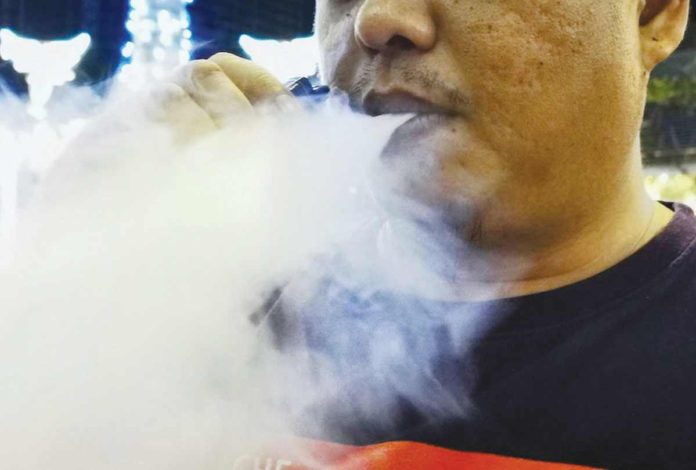 The Bureau of Internal Revenue will affix tax stamps on vape products starting next week to ensure that unregulated products do not spread across the country. Photo shows a man vaping outside a restaurant in Mandaluyong. GIGIE CRUZ/ABS-CBN NEWS FILEPHOTO