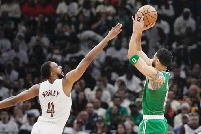 Boston Celtics’ Jayson Tatum (0) shoots over Cleveland Cavaliers' Evan Mobley (4). PHOTO COURTESY OF SUE OGROCKI/AP