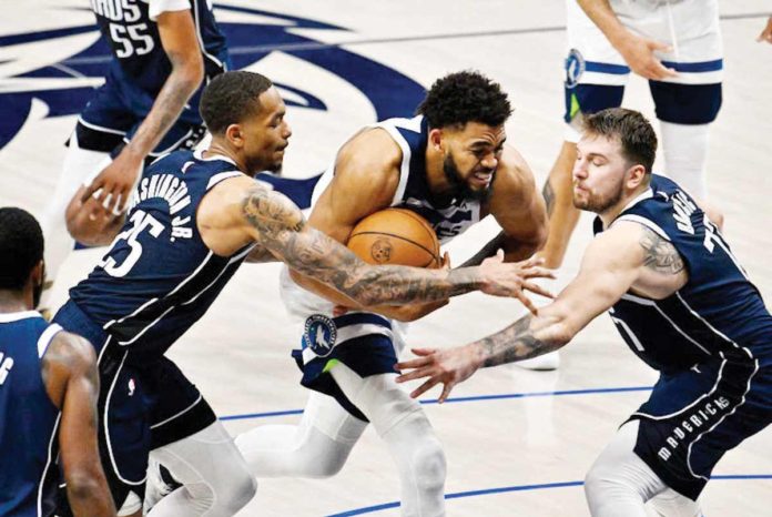 Minnesota Timberwolves’ Karl-Anthony Towns (32) drives to the basket past Dallas Mavericks’ P.J. Washington (25) and Luka Doncic (77). PHOTO COURTESY OF JEROME MIRON-USA TODAY SPORTS