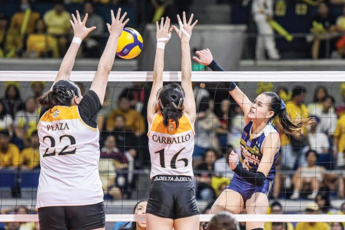 National University Lady Bulldogs’ Evangeline Alinsug scores against the defense of University of Santo Tomas Golden Tigresses’ Bianca Plaza. UAAP PHOTO