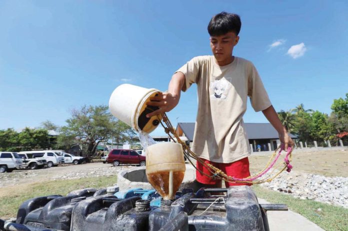 A boy fetches water from a deep well in Barangay Navais, Mandurriao, Iloilo City. Several deep wells in the city and province of Iloilo are drying up due to the ongoing El Niño phenomenon. ARNOLD ALMACEN/ILOILO CITY MAYOR'S OFFICE PHOTO