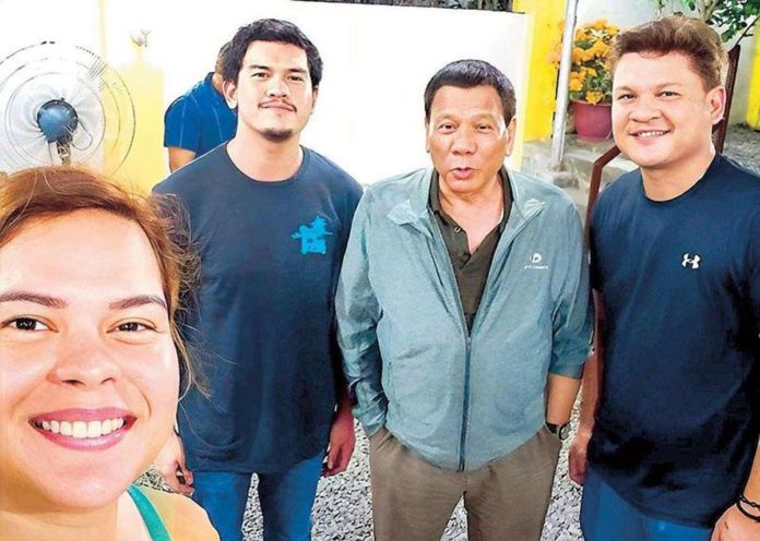 In this 2018 photo, then Davao City mayor Sara Duterte takes a selfie with her father, then President Rodrigo Duterte, and brothers Sebastian and Paolo.