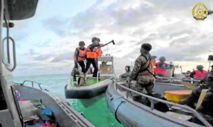 The Armed Forces of the Philippines, which released this photo, said one of the China Coast Guard members shown here (center) wielded a pickaxe and made threatening gestures in their encounter with Filipino troops on a resupply mission to Ayungin (Second Thomas) Shoal on June 17.