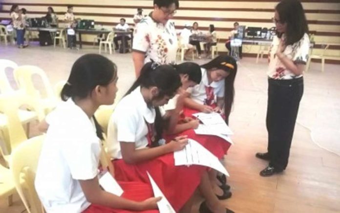 Comelec Antique Provincial Supervisor Lawyer Salud Milagros Villanueva (standing right) and Sibalom municipal election officer Ma. Luisa Alipis-Marfil (standing left) assist students in filling up their registration forms during the Voter Education and Registration Fair hosted by the University of Antique in Sibalom town on Tuesday, June 4. PNA photo by Annabel Consuelo J. Petinglay