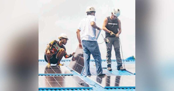 Members of environmental groups are helping residents of Barangay Coring, Basilisa and Dinagat Islands to install solar panels in their barangay gymnasium.  FILE PHOTO JILSON TIU/GREENPEACE