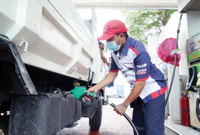 A Petron gasoline station attendant fills up the truck fuel tank. Petron Corp. will hike prices per liter of gasoline by P1.40, diesel by P1.75, and kerosene by P1.05 today, June 25. PNA PHOTO BY BEN BRIONES