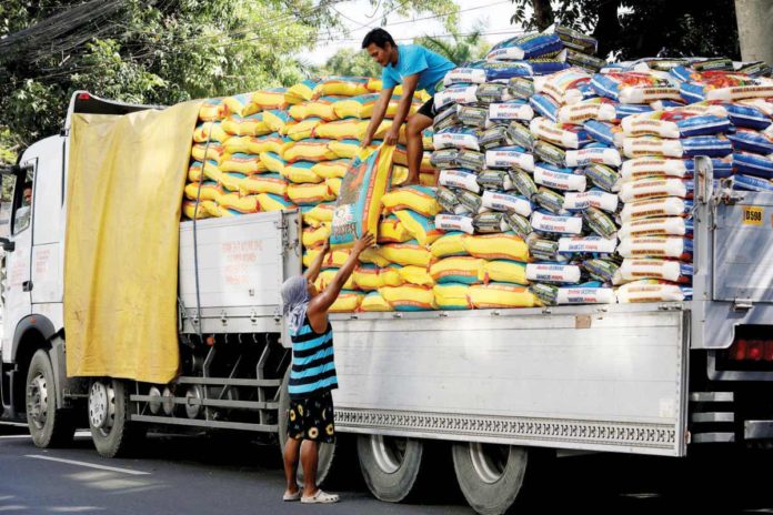 The Department of Agriculture raises concerns that tariff reduction would not result in significant lowering of rice prices and could also adversely affect local farmers. Photo shows workers unloading sacks of rice from a truck along Dagupan Street in Tondo, Manila. PNA PHOTO BY YANCY LIM