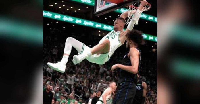 Boston Celtics’ Kristaps Porzingis hangs into the ring after completing a two-handed dunk. AP PHOTO