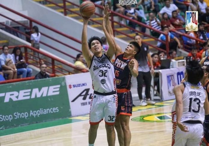 Bacolod City of Smiles’ JM Manalang (32) attempts to score against the defense of Pangasinan Heatwaves’ JR Caasi (15). MPBL