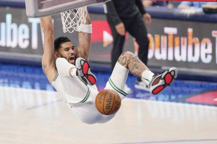 Boston Celtics’ Jayson Tatum hangs into the ring after a two-handed dunk. AP PHOTO