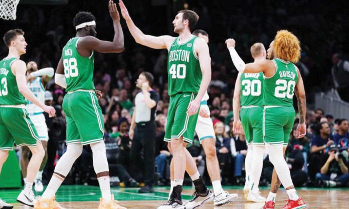 Neemias Queta (88) and Luke Kornet (40) exchange high fives during Boston Celtics’ recent game in the 2023-2024 NBA Season. Photo courtesy of USA Today Sports. 