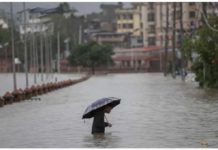 A person wades through a flooded street caused by the swollen Bagmati River after torrential rains in Kathmandu, Nepal on July 6, 2024. Streets in the Nepalese capital Kathmandu were flooded over the weekend from overflowing rivers. EPA