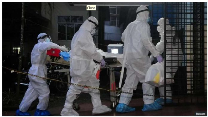 A patient with Nipah Virus is transferred in hospital. A group of people in personal protection gear are pushing the patient on a stretcher. Reuters