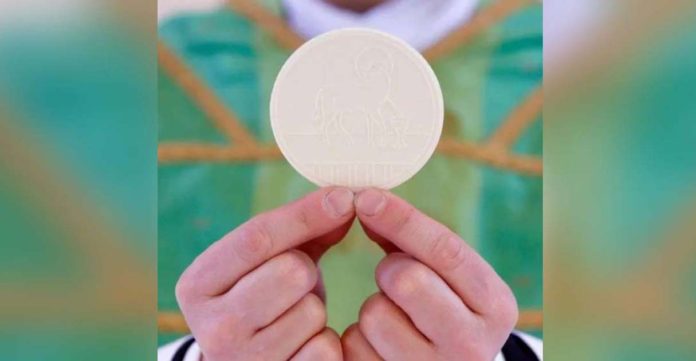 A priest holds the Holy Communion by his fingertips. Also called the Eucharist, Holy Communion is a sacrament that commemorates the Last Supper. GETTY IMAGES