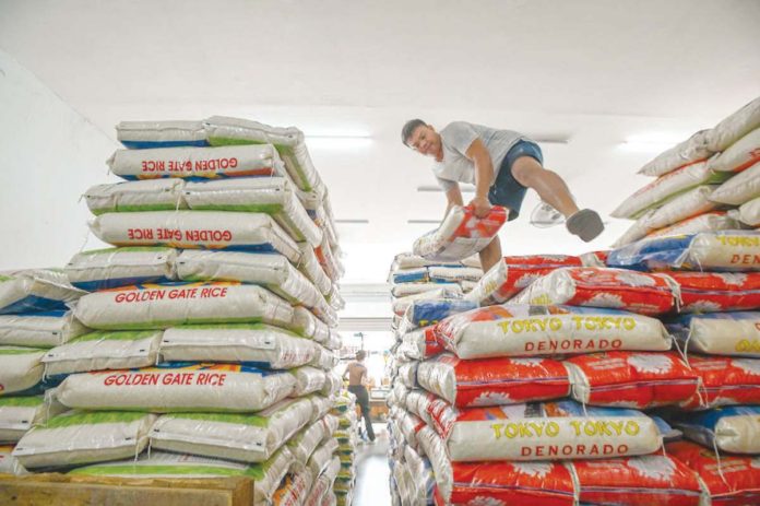 A worker arranges sacks of rice at a local rice store in Quezon City. MARIA TAN/ABS-CBN NEWS PHOTO