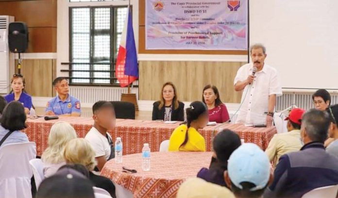 Gov. Fredenil Castro (standing, right) leads the distribution of financial assistance to 94 former rebels from Capiz on Tuesday, July 23. CAPIZ PROV’L GOV’T COMMUNICATIONS GROUP/FACEBOOK PHOTO