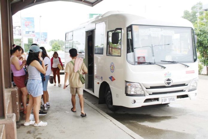 Passengers board a minibus in Iloilo City. Consolidated transport cooperatives and/or companies have secured millions of pesos in bank loans to buy minibuses in line with the Public Utility Vehicle Modernization Program. Suspending the program, they say, would be detrimental to their operation. IME SORNITO/PN