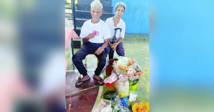 Food Stamp Program beneficiaries Rafael Villarena and wife Melinda of Barangay Canlosong, EB Magalona, Negros Occidental redeem food packages using their Electronic Benefit Transfer card given by the Department of Social Welfare and Development. They are among the region’s food poor. PHOTO AND CAPTION FROM DSWD WESTERN VISAYAS