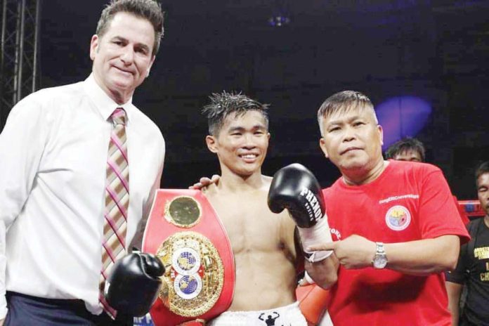 Filipino boxer Pedro Taduran (center) reclaims the IBF minimumweight championship. PHOTO COURTESY OF PHENOM BOXING