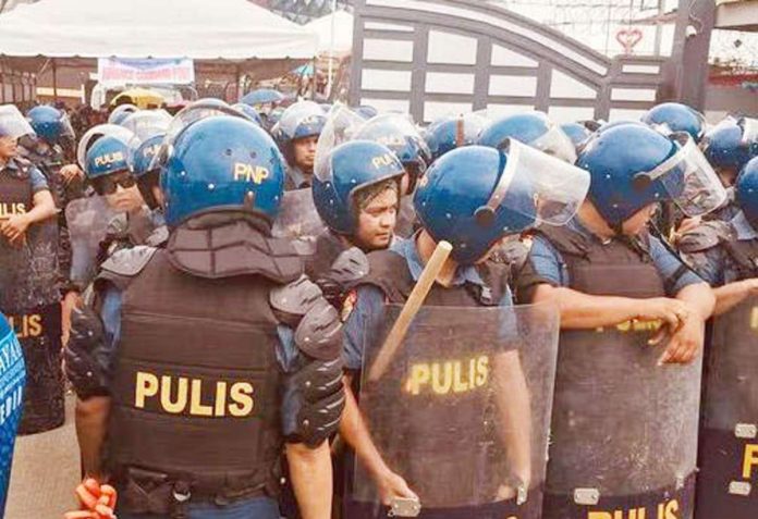 Police officers assemble outside the Kingdom of Jesus Christ compound in Davao City in this photo taken on August 24, 2024. Their objective is to serve an arrest warrant on fugitive televangelist Apollo Quiboloy. PHOTOS BY GERMELINA LACORTE