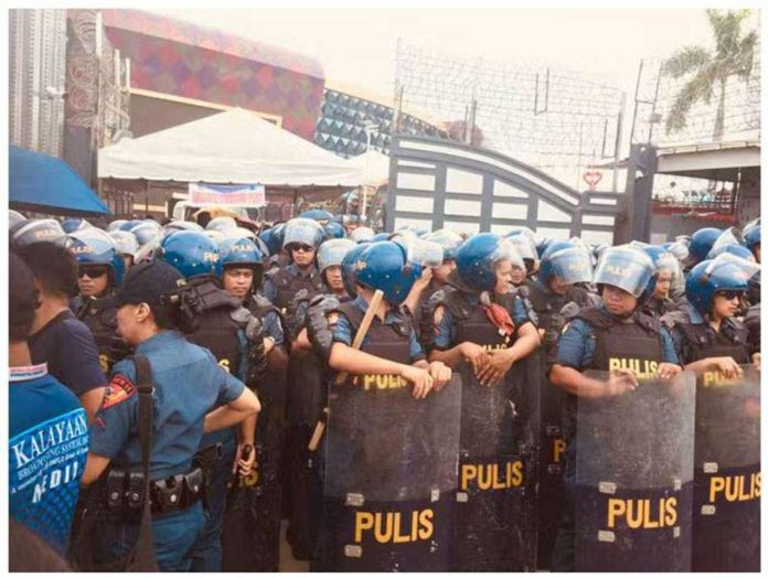 Policemen prepare to enter the Kingdom of Jesus Christ Compound in Davao City in what Police Brigadier General Nicolas Torre III calls as the second phase of the operation geared at arresting Pastor Apollo Quiboloy who faces charges for violation of the Special Protection of Children Against Abuse, Exploitation, and Discrimination Act, and qualified human trafficking. PHOTO BY GERMELINA LACORTE | INQUIRER MINDANAO