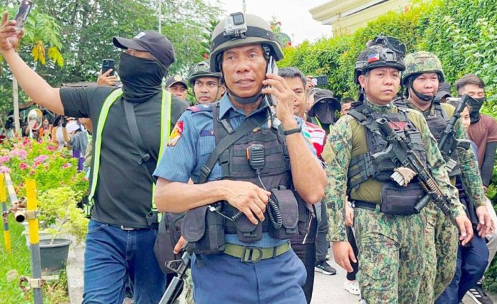 Police Regional Office 11 director Police Brigadier General Nicolas Torre III is seen with armed police officers inside the Kingdom of Jesus Christ Compound in Davao City on Saturday. PHOTO COURTESY OF SMNI NEWS