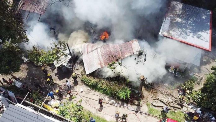 Firefighters and residents try to contain the fire that broke out in a residential area in Barangay Tangub, Bacolod City on Wednesday, August 21. PHILIPPINE EMERGENCY ALERTS PHOTO