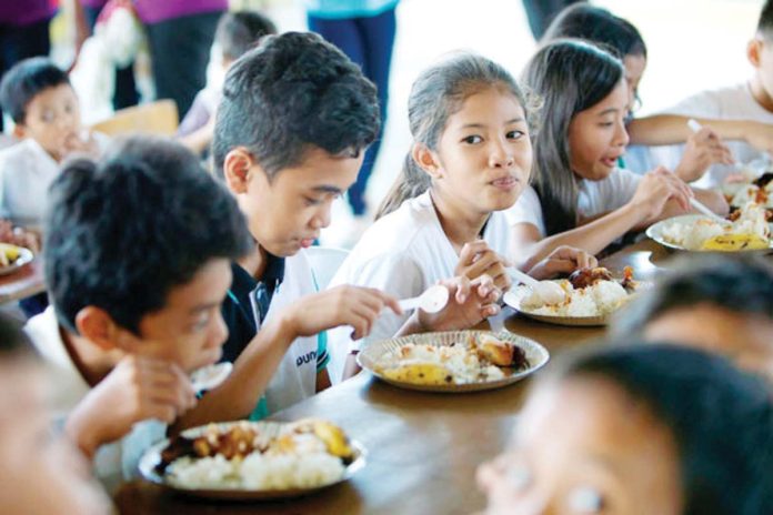 National Economic and Development Authority says the monthly food threshold for a family of five is P9,581 or about P64 per person per day. Photo shows students in San Fernando, Pampanga enjoying their meal during a feeding session. PAGCOR PHOTO