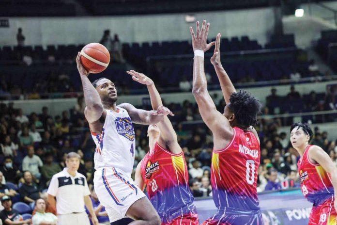 NLEX Road Warriors’ Myke Henry goes for a one-hander basket against the defense of Phoenix Fuel Masters’ Jayveous McKinnis. PBA PHOTO