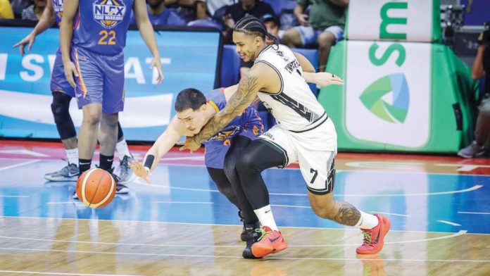 NLEX Road Warriors’ Robert Bolick Jr. dribbles the ball away from the defense of Blackwater Bossing’s James Kwekuteye. PBA PHOTO