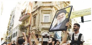 A group in Beirut, Lebanon carry a photo of slain Hezbollah leader Hassan Nasrallah and chant slogans. GETTY IMAGES