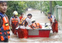 Rescue volunteers with a boat wade through a flooded road in Taungoo, Myanmar, on September 12, 2024, amid heavy rains triggered by Typhoon Yagi. EPA