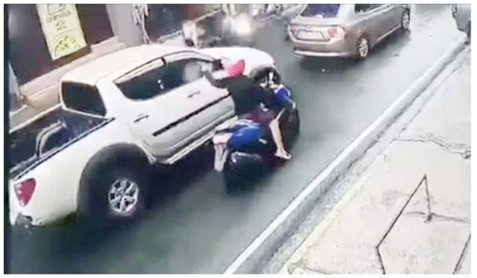 This screenshot from a closed circuit television footage shows a motorcycle-riding gunman firing shots at the vehicle of Philippine Charity Sweepstakes Office’s Board Secretary Wesley Barayuga in Mandaluyong City in July 2020. Screenshot provided by the Mandaluyong City PNP