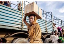 A Sudanese girl who have fled the war with her family carries a box of belongings after arriving at a transit center for refugees in Renk in South Sudan. GETTY IMAGES