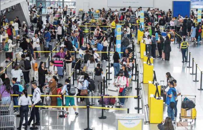 Outbound travelers queue at the Ninoy Aquino International Airport Terminal 3 check-in and immigration counters. MARIA TAN/ABS-CBN NEWS PHOTO