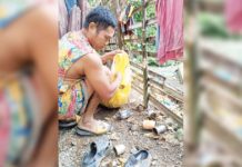 A resident of Barangay Codiong, Libertad, Antique eliminates mosquito breeding sites such as empty tin cans. BARANGAY CODIONG, LIBERTAD/FACEBOOK PHOTO