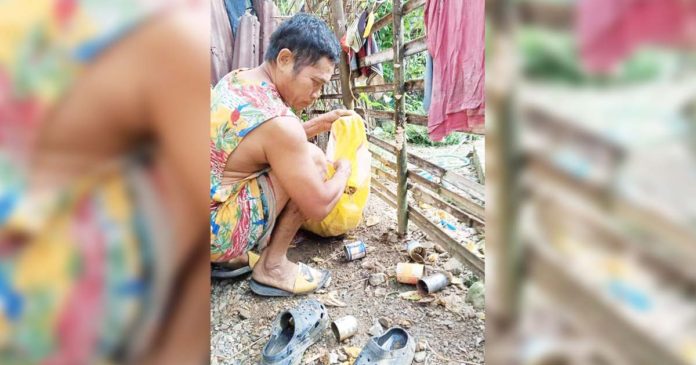 A resident of Barangay Codiong, Libertad, Antique eliminates mosquito breeding sites such as empty tin cans. BARANGAY CODIONG, LIBERTAD/FACEBOOK PHOTO