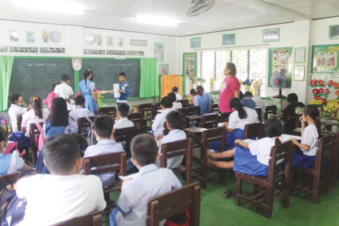 The Department of Education Region 6 says basic education services will remain uninterrupted despite the resignation of several public school teachers seeking better opportunities. Photo shows a teacher overseeing a reading program at a public elementary school in Barotac Nuevo, Iloilo. JASPER JAN SANTOS PHOTO