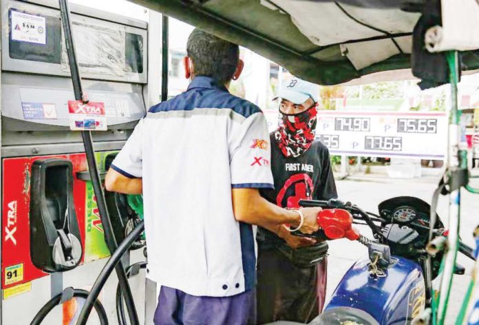 A gasoline station clerk refills a tricycle’s tank at a station in Manila. GEORGE CALVELO/ABS-CBN NEWS FILE PHOTO