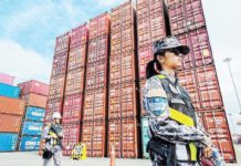 Port officers guard containers of imported rice ahead of an inspection by Philippine Ports Authority officials of a warehouse at the Port of Manila on Sept. 21, 2024. RYAN BALDEMOR/PHILSTAR.COM PHOTO