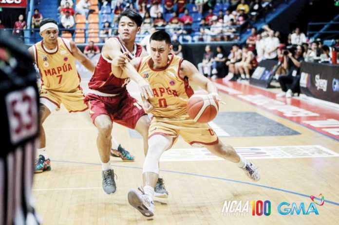 Mapua University Cardinals’ Clint Escamis wards off a University of Perpetual Help Altas’ defender. PHOTO COURTESY OF NCAA/GMA SPORTS