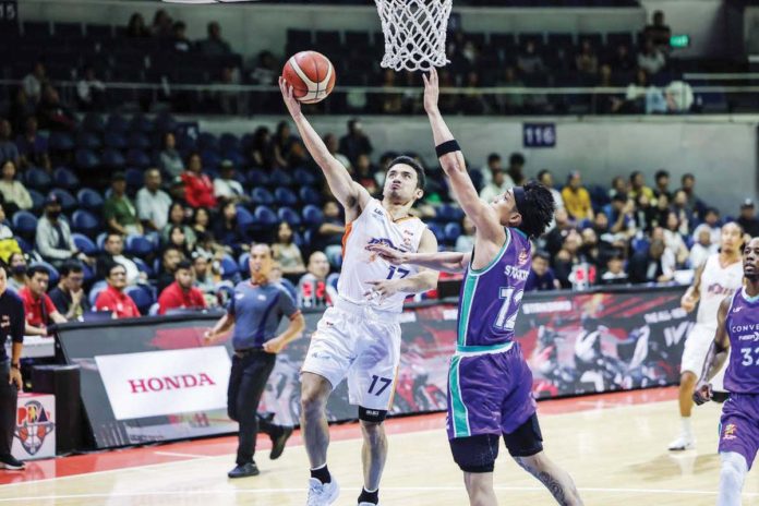 Ilonggo Antonio Jose Caram of Meralco Bolts attacks the defense of Converge FiberXers' Alec Stockton for a layup. PBA PHOTO