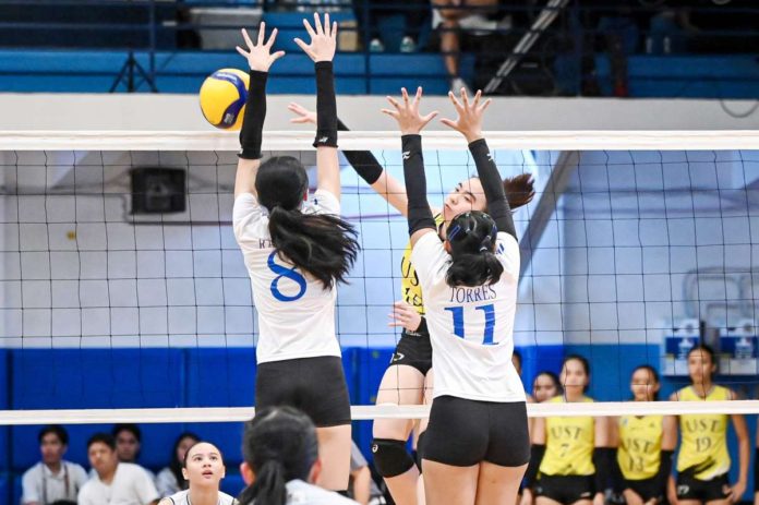 Negrense Kimberly Rubin of University of Santo Tomas Junior Golden Tigresses smashes the ball against two Ateneo de Manila University Blue Eaglets defenders. UAAP PHOTO