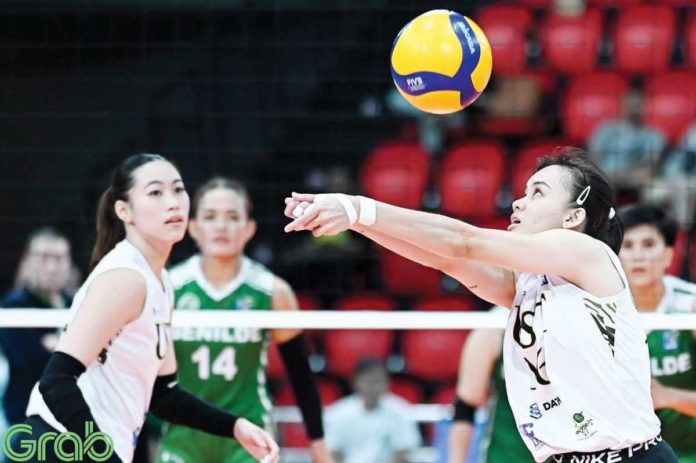 Negrense Cassie Carballo of University of Santo Tomas Golden Tigresses tosses the ball as her teammate Pia Abbu looks on. PHOTO COURTESY OF V-LEAGUE