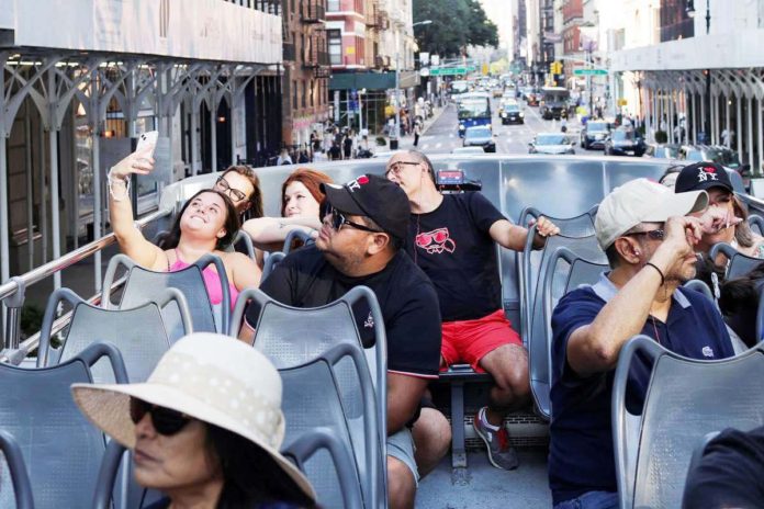 A tourist takes a group selfie on the ‘Big Bus’ at Times Square in New York City on August 27, 2024. REUTERS/KENT J EDWARDS PHOTO