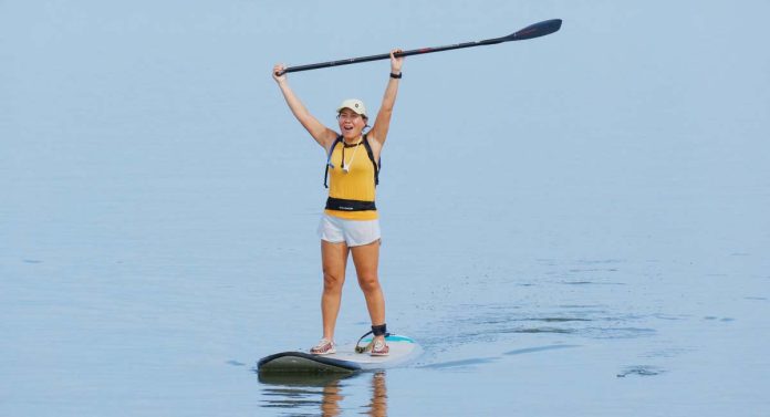 Ilongga influencer Lucy Lynette Ponce Uygongco, 54, rejoices by raising her paddle after arriving at Pasil Sandbar in Brgy. Latasan, EB Magalona, Negros Occidental.