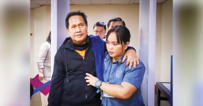 Pastor Apollo Quiboloy of the Kingdom of Jesus Christ is being escorted by a policewoman into the Senate to attend the Committee on Women’s hearing, his first since the body started its investigation in December 2023. PHOTO FROM SENATE PRIB