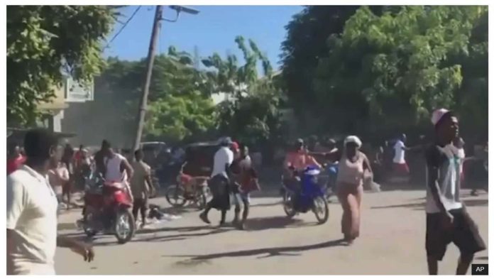 People could be seen fleeing violence on motorbikes and on foot in Haiti. AP