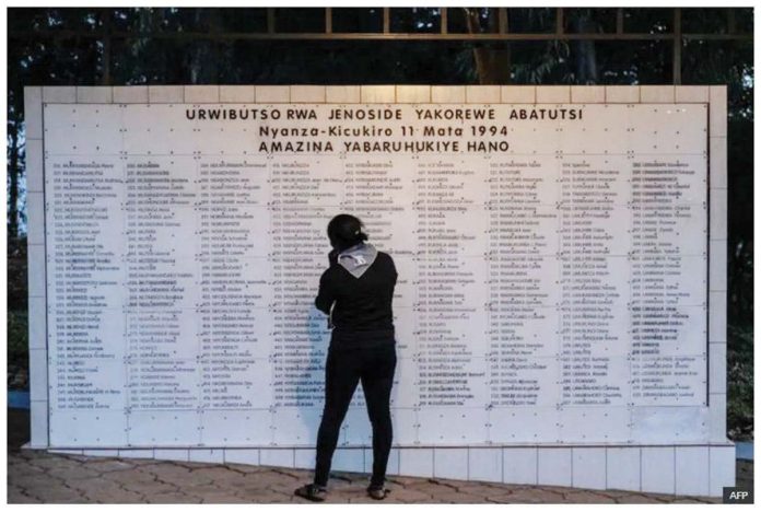 A woman stands in front of a memorial of list of names of people killed during the 1994 Genocide against the Tutust at Nyanza Genocide Memorial Centre in Kigali in April 2024. AFP