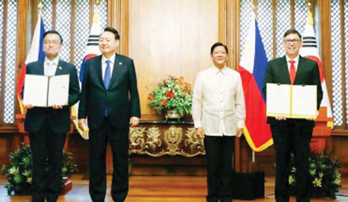 Korea's Deputy Prime Minister and Minister of Economy and Finance Choi Sang-mok (left) and Finance Secretary Ralph Recto (right) pose for a photo during the ceremonial exchange of agreements in Malacañang Palace on Oct. 7, 2024. The signing was witnessed by President Ferdinand R. Marcos Jr. (2nd from right) and South Korean President Yoon Suk Yeol (2nd from left). DOF PHOTO